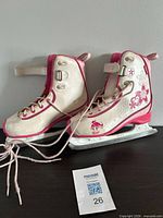 Full pair of CCM white and pink size 4 ice skates on surface