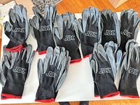 Ten gloves (five pairs) laid out showing front and back, brand logo visible