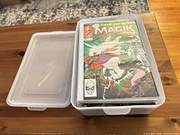 Stack of bagged comic books inside plastic box, top issue Storm and Illyana: Magik visible
