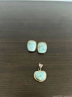 Front view of earrings and pendant showing stone color and setting