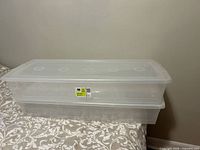 Two stacked clear underbed storage bins with lids
