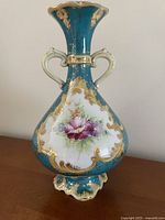 Front view showing floral design, handles, and pedestal foot