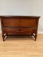 Front view showing chest, drawer, turned feet