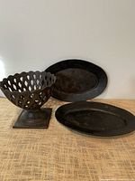 Group view of cast iron lattice bowl and two oval platters