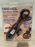 Front view of sealed Dremel grout removal kit showing attachment and bits
