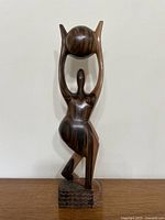 Front view of ebony sculpture on wood surface