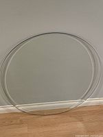 Full view of circular glass top leaning against wall