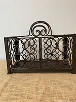 Front view of wrought iron holder showing scrollwork design and dimensions