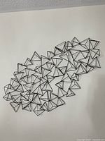 Full view of black metal geometric wall art on wall