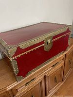 Perspective view of trunk showing front, lid, lock, hardware