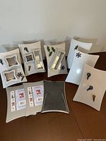 Front view of nine magnetic boards, some unpackaged, some sealed, magnets and storage boxes visible