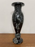 Front view of polished black marble vase showing overall form and veining