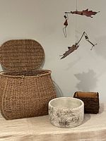 Overall view: seagrass basket, faux birch round planter, real bark square planter, portion of metal mobile