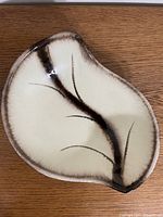Top view of cream and brown leaf-shaped ceramic dish