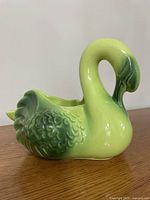 Front view of green glazed ceramic swan planter