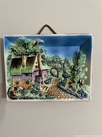 Front view of ceramic plaque showing full pastoral scene