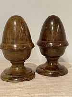 Front view of both metal finials on pedestal bases