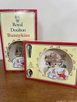 Front view of both boxed Bunnykins infant sets