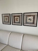 All three framed prints mounted on wall above sofa