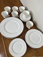 Stacked dinner, salad and bread plates with cups and saucers displayed
