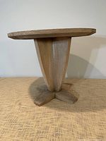 Side view of round teak table showing pedestal and base