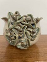 Front view showing sculptural loop decoration and glaze colors