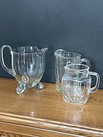 Group of three clear glass pitchers