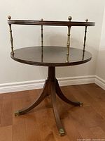 Full view of round two-tier wood and brass end table