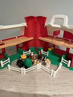 Overall view of barn playset with tractor, farmer, animal figures and fences
