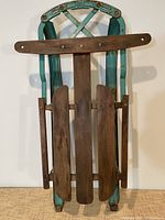 Full front view of sled showing wood slats and teal metal frame