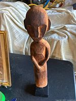 Front view of antique hand-carved wooden African tribal sculpture showing facial carving detail and upper body.