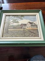Full view of the framed painting showing the rural house and surrounding fields under a large tree with greenery.