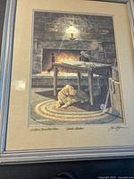The full framed print showing the warm indoor scene by the fireplace, a man fly-tying fishing materials, and a dog resting on a braided rug.