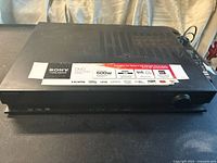 Front and top view of Sony DVD and CD player showing brand logo and multiple format/support labels.