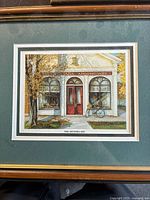 Front view of the framed artwork showing the entire scene of The Niagara Apothecary storefront with trees and a bicycle.