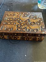 Top and side view showing detailed folklore and geometric hand carvings on the wooden box