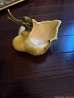 Photo of a vintage green swan planter showing the swan's full body, textured feathers, and open planter section.