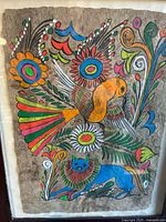 Full view of the vintage Mexican Amate bark painting featuring colorful bird and blue animal with flowers.