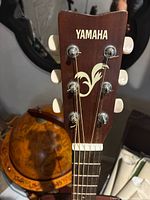 Close-up of headstock showing Yamaha logo and decorative emblem on the FG-400A guitar
