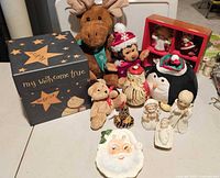 Full view of all items on display including the plush animals, Lenox nativity figures, Santa plate, nesting dolls, and decorative box.