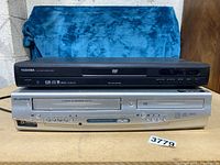 Photo showing both Sylvania VHS/DVD combo and Toshiba DVD player stacked horizontally.