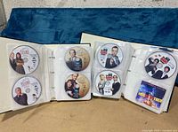 Photo of 2 binders with Frasier, Big Bang Theory, and Spin City DVDs organized in plastic sleeves within binders.