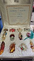 View of 12 Old World Christmas blown glass ornaments in original box showing certificate of authenticity dated August 1 1988