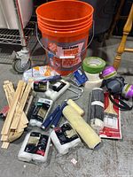 Photo showing orange Home Depot bucket with all painting supplies arranged on floor around it