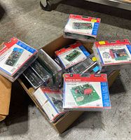 Box containing multiple Velleman electronic kits in clear plastic packaging, packed neatly with visible model names and numbers on front.