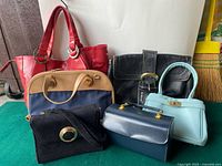 Grouping of six vintage purses displayed together showing different sizes, materials, and colors.