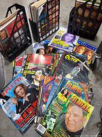 Photo showing various vintage magazines stacked and fanned out, including Scarlet Street, The X Files, Filmfax, Outré, and Newsweek titles.
