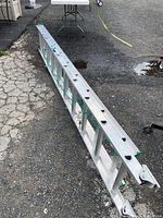 Full collapsed ladder on ground showing overall length and condition