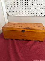 Closed cedar chest front view with latch and inscription visible