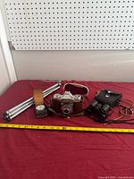 Group shot showing camera, tripod, light meter, binoculars